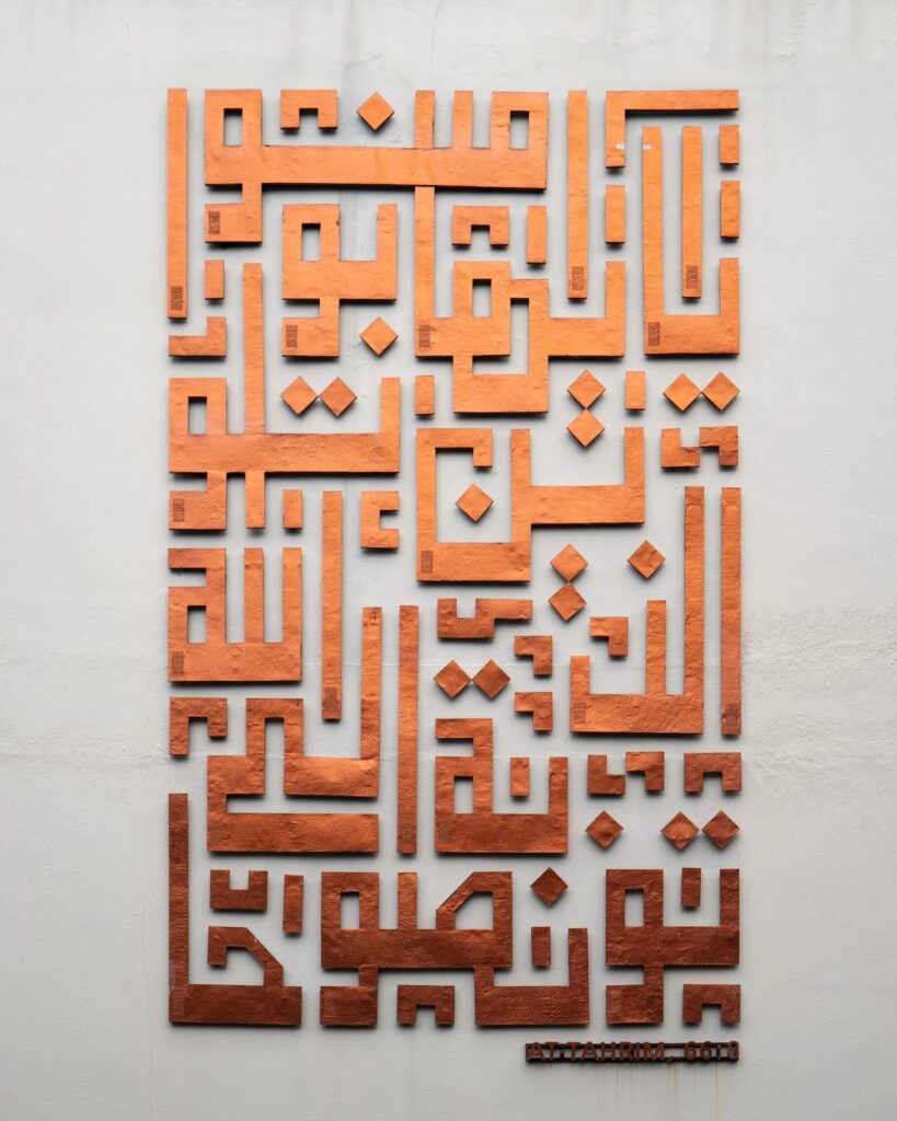 جدارية مودرن بارزة تعتمد على الخط العربي الهندسي والزخارف التراثية بلون برونزي دافئ لتزيين الحوائط، مما يعكس الهوية الأصيلة في أنماط التصميم الداخلي.