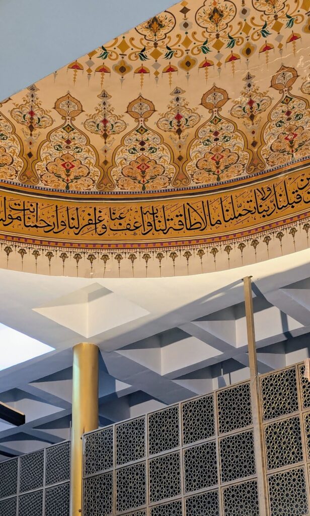 فاصيل معمارية لقبة مسجد تراثي يبرز فيها الخط العربي التقليدي والزخارف الهندسية والنباتية الملونة، لتجسيد فخامة النمط التراثي الإسلامي في التصميم الداخلي.